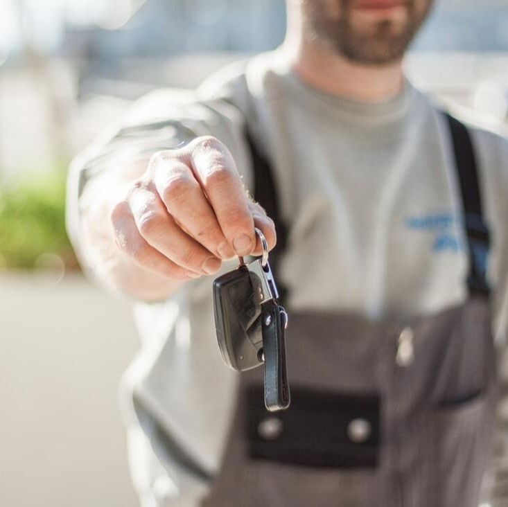 Mechanic returning keys to car owner